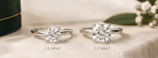 Two lab-grown diamond solitaire rings comparing 1 carat and 2 carat diamond sizes on a soft ivory background.